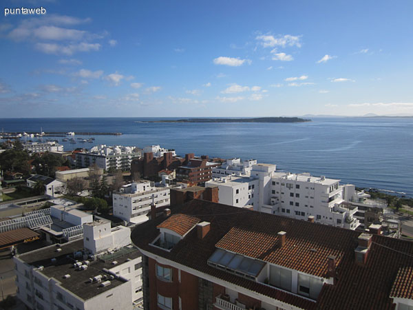 Living desde la esquina derecha hacia el suroeste. Est� acondicionado con cuatro sillones, uno de tres cuerpos y tres de individuales en torno a una mesa baja en madera y vidrio. Las sillas de pl�stico que se aprecian pertenecen al balc�n terraza.