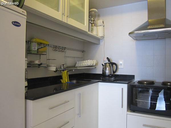 Kitchen detail. Refrigerator, microwave, coffee maker.