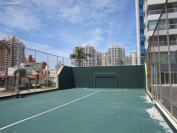 Cancha multiuso en cemento hacia el contrafrente del edificio.