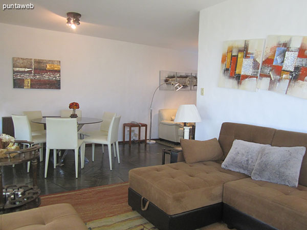 View from the middle of the living room towards the door to the apartment. <br><br>At the bottom of the image, access to the kitchen and the space where the washer and electric dryer tender.