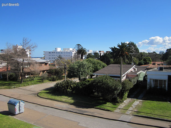 Vista desde el balcn hacia el este sobre el techo de la casa lindera, entorno de barrio residencial.