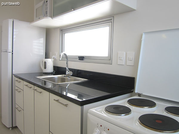 Kitchen. Integrated into the living room by a breakfast bar. <br><br>Fitted with under counter, shelves, electric stove and microwave.