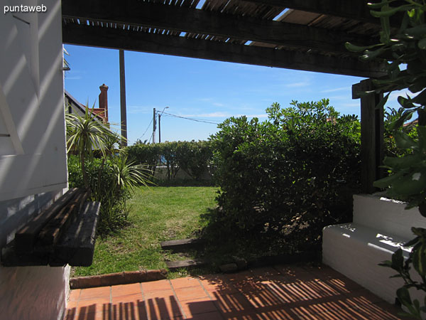 Patio with pergola on the north side of the apartment below the garden next to backyard where the grill is. <br><br>It is fitted with table and chairs for barbecues.