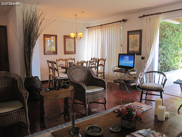 View of room in the living room from the corner of the north side next to the window to the door. <br><br>In the background, access to the kitchen.