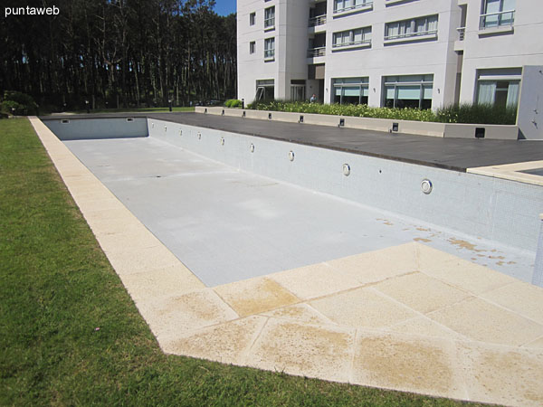 Piscina al aire libre en el jardn trasero del edificio.<br><br>Al fondo de la imagen el solarium acondicionado con tumbonas.