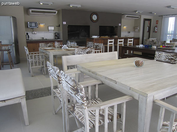 Detalle de mesa rectangular al centro de la barbacoa con dos bancos a cada largo.