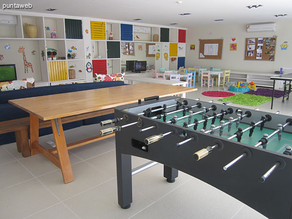 Espacio de estar techado en madera entre la barbacoa y la sala para adolescentes y chicos.