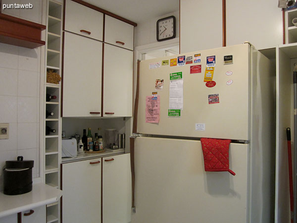 Partial view of the kitchen from the front door to the southeast corner.<br><br>Refrigerator.