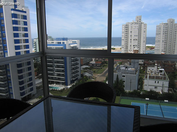 Table with four chairs in the enclosed terrace apartment balcony.