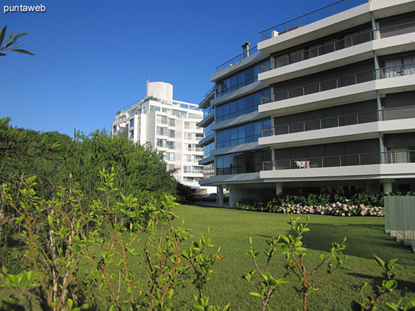 Garden space and the outdoor pool is delimited by glass panels.