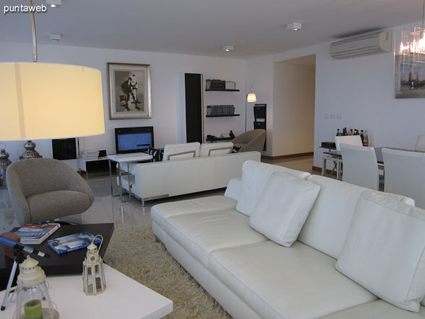 General view of the living room from the west side near the exit to the balcony in L.<br><br>The dining space has a metal and glass table and eight chairs.<br><br>It has air conditioning.