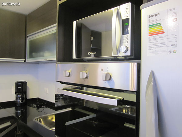 Overview of the kitchen. U–Table with shelves and furniture on and under table.<br><br>Double sink, one on each side.