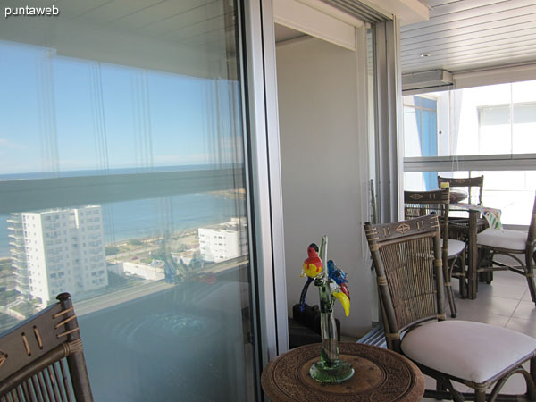 The balcony is closed in L and has barbecue and square glass table with four chairs.