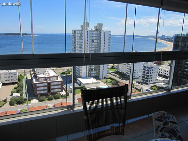 Detail glass square table with four chairs and wood in the enclosed balcony.