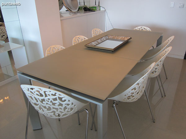 Dining space in the living room environment. Equipped with large rectangular table and eight chairs.