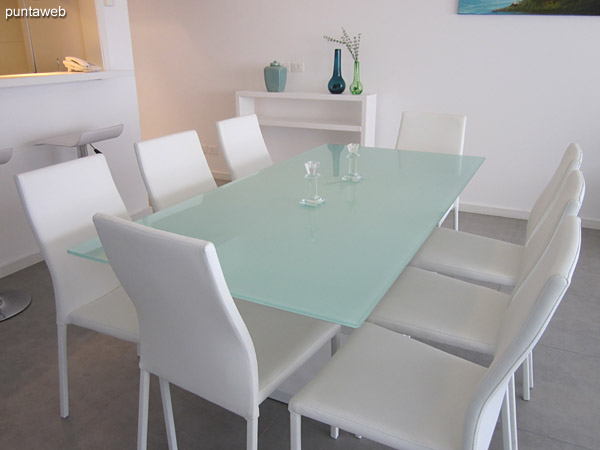 Dining space integrated into the living room environment.<br><br>Equipped with rectangular glass and wood table with eight chairs.