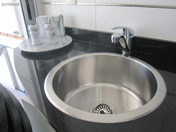 Washing machine in the kitchen, to the front and to the exit to the terrace balcony next to the barbecue.