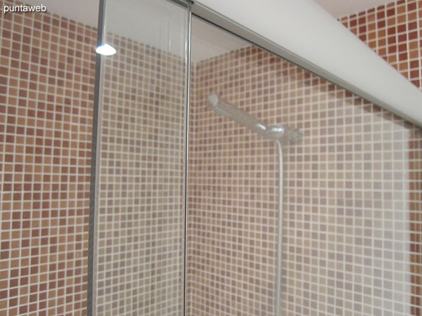 Shower space and fixtures in the bathroom of the suite. It features door.