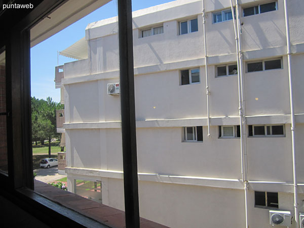 Vista hacia el lateral norte desde la ventana del living comedor sobre entorno de jardn del edificio vecino.