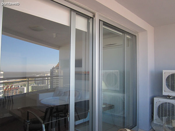 Balcony terrace equipped with glass round table with two chairs.