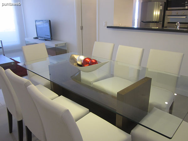 View of dining space. Equipped with rectangular glass table and eight chairs.