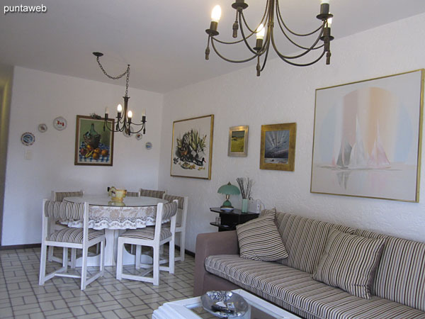 General view of the living room. Equipped with sofa bed and round table with four chairs.