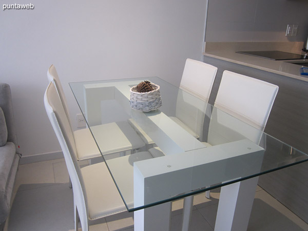 Mesa de comedor en vidrio con cuatro sillas.