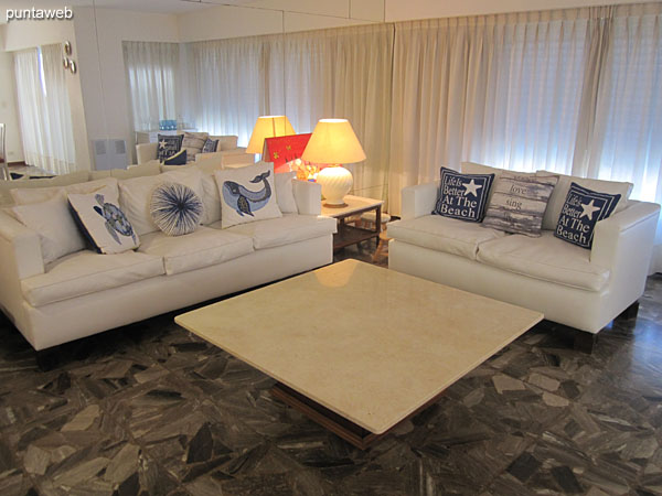 Living space equipped with armchairs of two and three bodies around a low table.