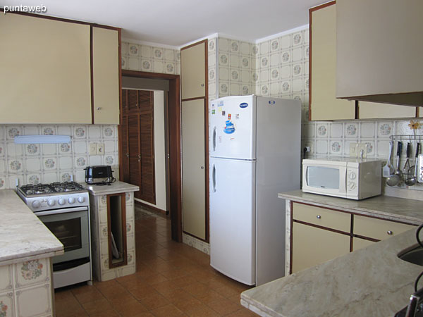 Cocina, amplia, accesible desde el espacio de comedor y del pasillo hacia los dormitorios y dormitorio de servicio.