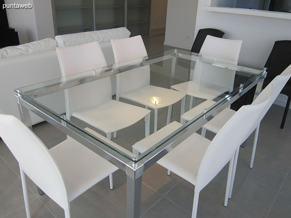 Rectangular dining table in glass and metal arranged on the west side of the living room.<br><br>It has six chairs.