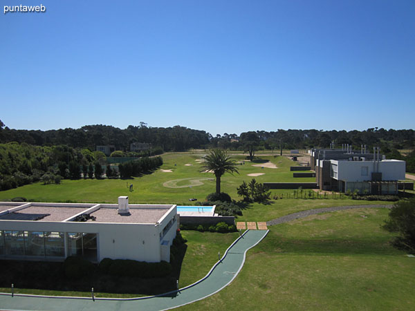 The green space consists of a four–hole golf course.<br><br>In the foreground the barbecue with two grills next to the outdoor pool.