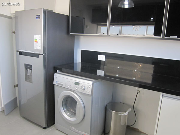 The kitchen has washing machine. Refrigerator with freezer.