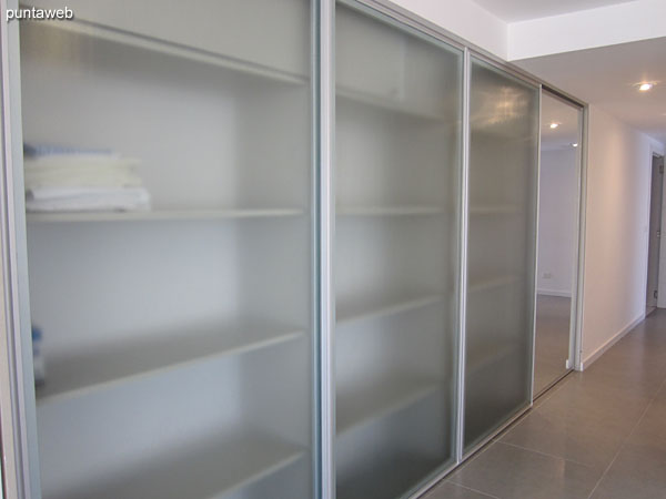 Large wardrobe / closet with glass doors located on the side of access to the living room.