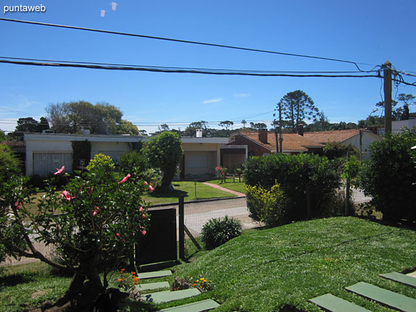 View towards the side street of the building on the surroundings of the fenced garden from the living room window.