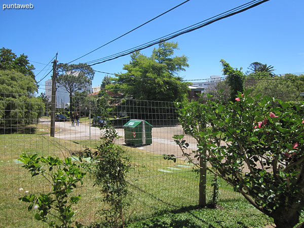 View towards the side street to the building from the fenced garden and with access gate of the apartment.