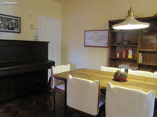 Dining space with rectangular wooden table with six chairs.