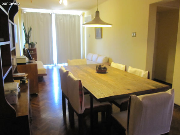 Dining space with rectangular wooden table with six chairs.