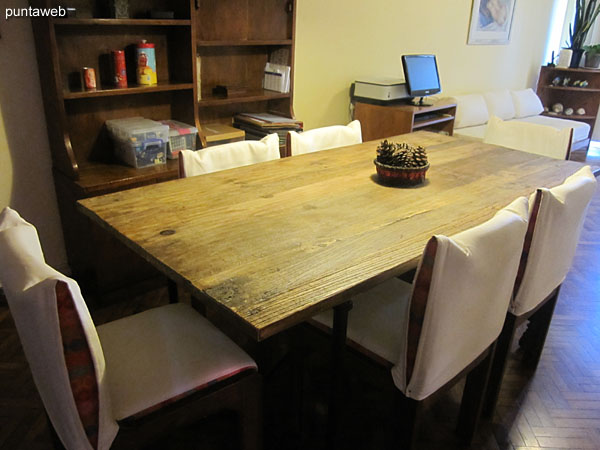 Dining space with rectangular wooden table with six chairs.
