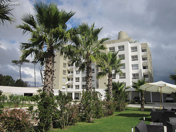 View towards the facade of the building's back of the building from the surrounding garden to the outdoor pool.