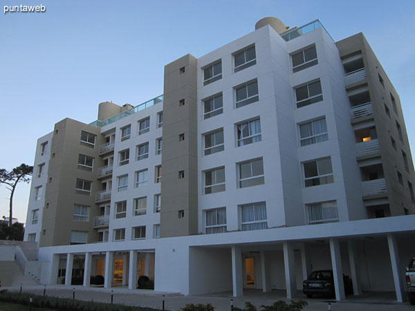 View towards the facade of the building's back of the building from the surrounding garden to the outdoor pool.