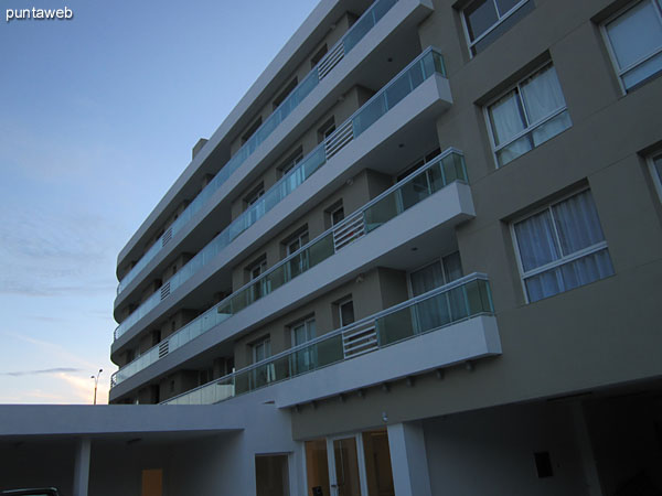 View towards the facade of the building's back of the building from the surrounding garden to the outdoor pool.