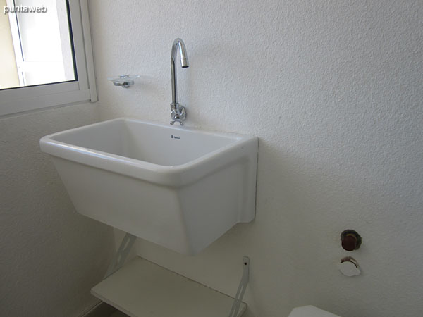 Laundry room with sink and tender. The building has coin–operated washing machines in the basement.