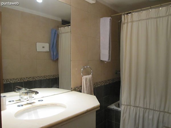 Second bathroom Shared bathroom between the second and third bedrooms. It has a shower, shower curtain and bathtub.