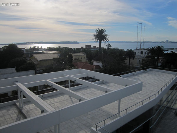 Vista de las terrazas desde la ventana del gimnasio en el último piso. Al fondo, la piscina al aire libre, el puerto y la bahía de Punta del Este.