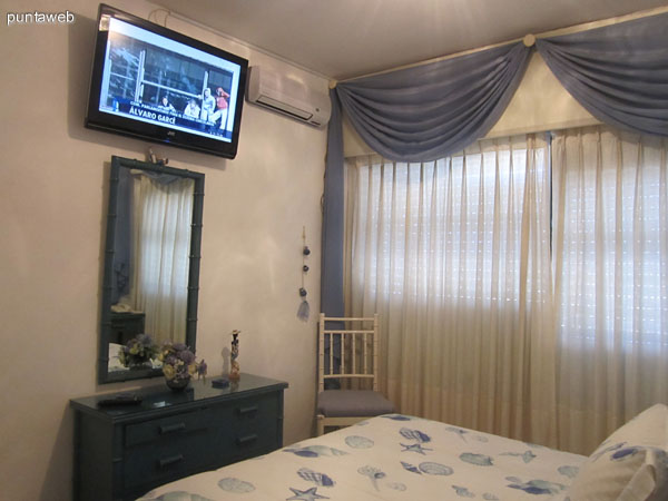 Dormitorio. Acondicionado con cama matrimonial y televisor de pantalla plana. La ventana ofrece vistas al oeste y suroeste sobre la península de Punta del Este y la playa El Emir.