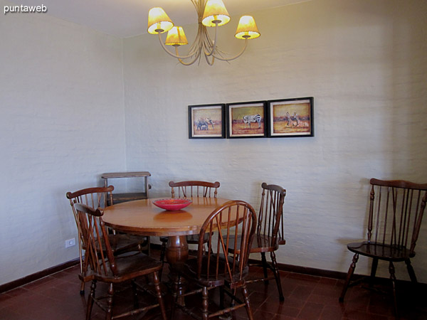 Dining room space located at entry living room. <br><br>Conditioning with round wooden table with six chairs. <br><br>To the left of the image the kitchen door.