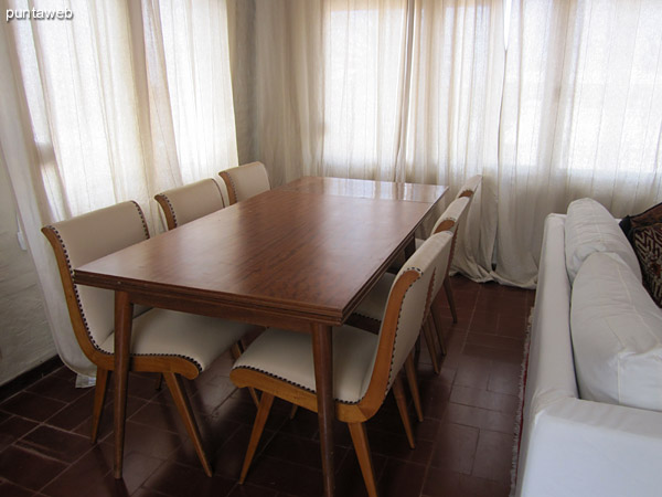 Space dining room from the kitchen door. <br><br>In the background reading area with two armchairs conditioning into play with the rest of the chairs in the room.