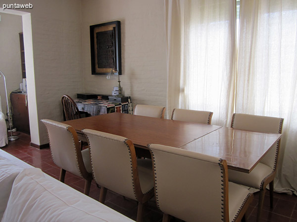 Dining space on the side of the environment. Conditioning with important rectangular table with six matching upholstered chairs.