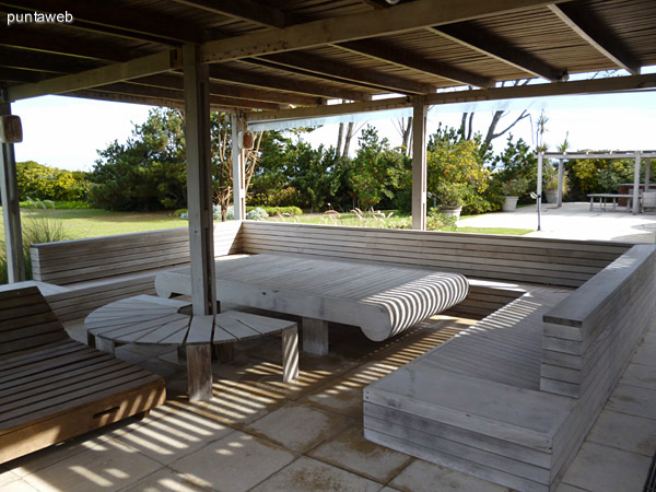 Segunda pergola con reposeras, bancos y mesas en madera, en das de verano se decoran con telas para crear un ambiente fresco para descansar al aire libre y a la sombra.