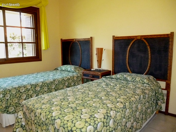 Cuarto dormitorio equipado con dos camas de una plaza, vistas exteriores a la calle y entorno.